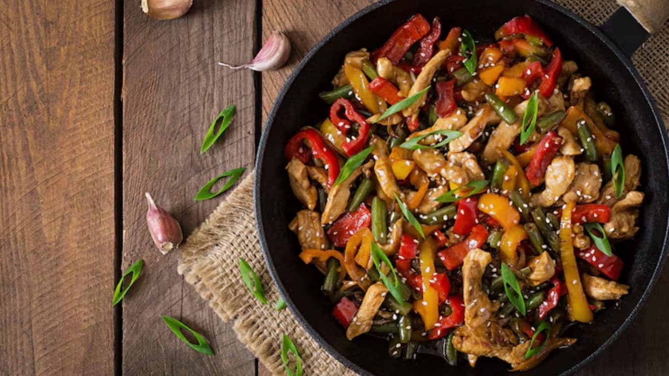 Colorful chicken stir fry in cast iron skillet