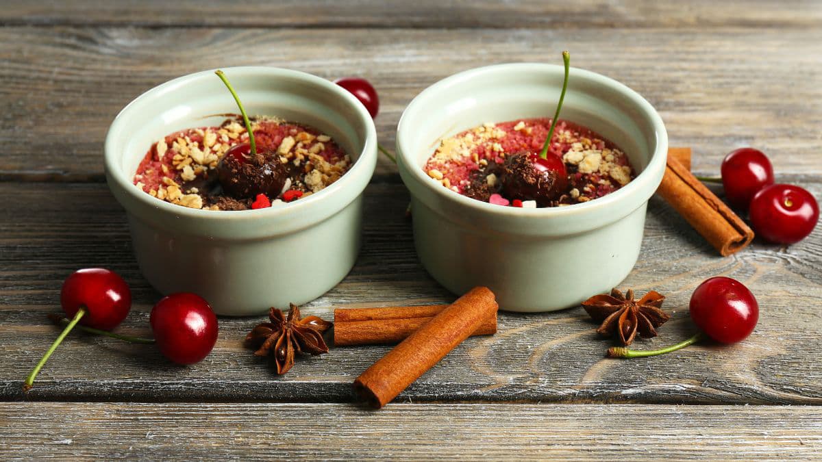 2 ramekins of cherry desserts surrounded by spices
