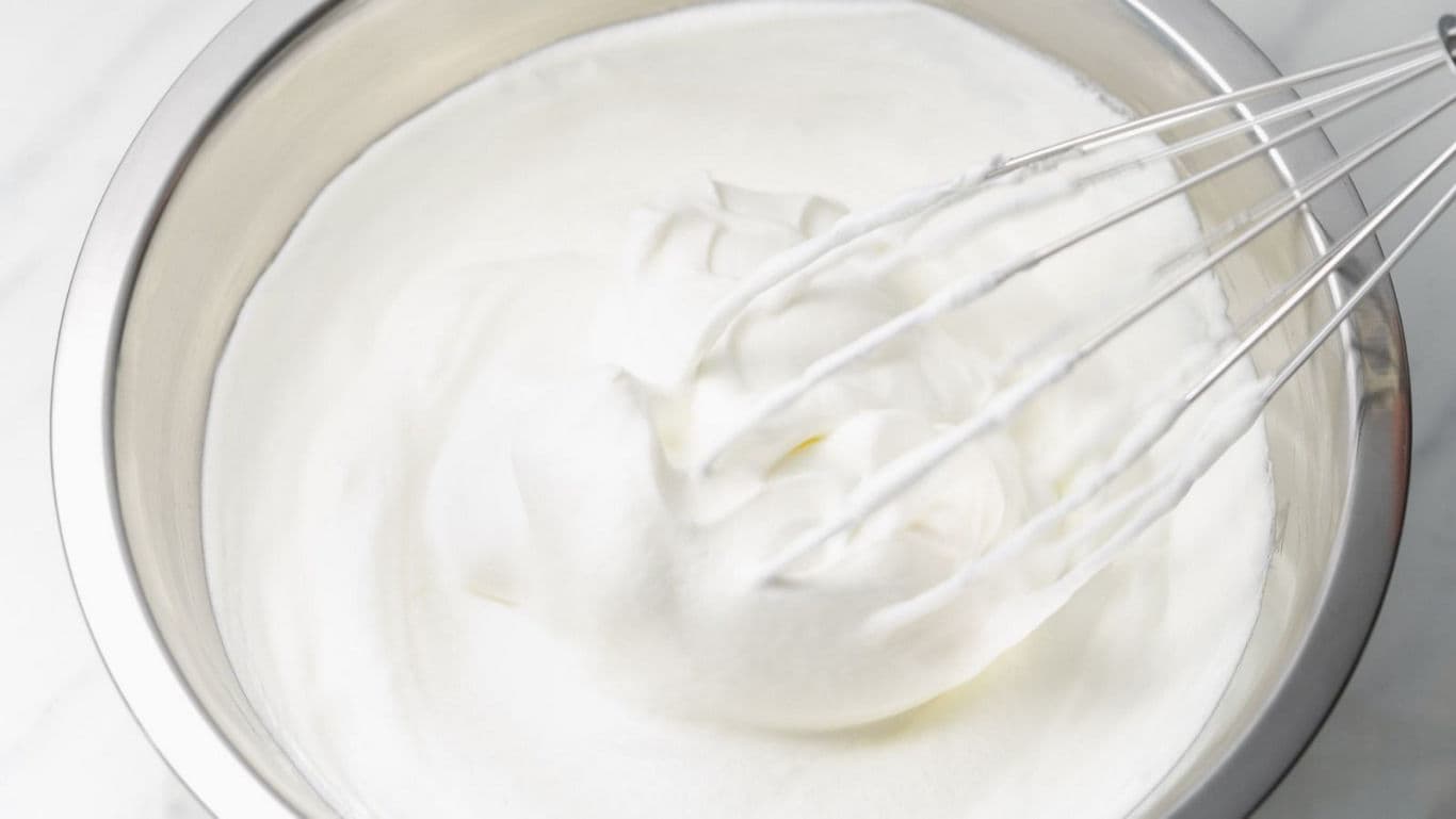 Whipped cream in metal mixing bowl