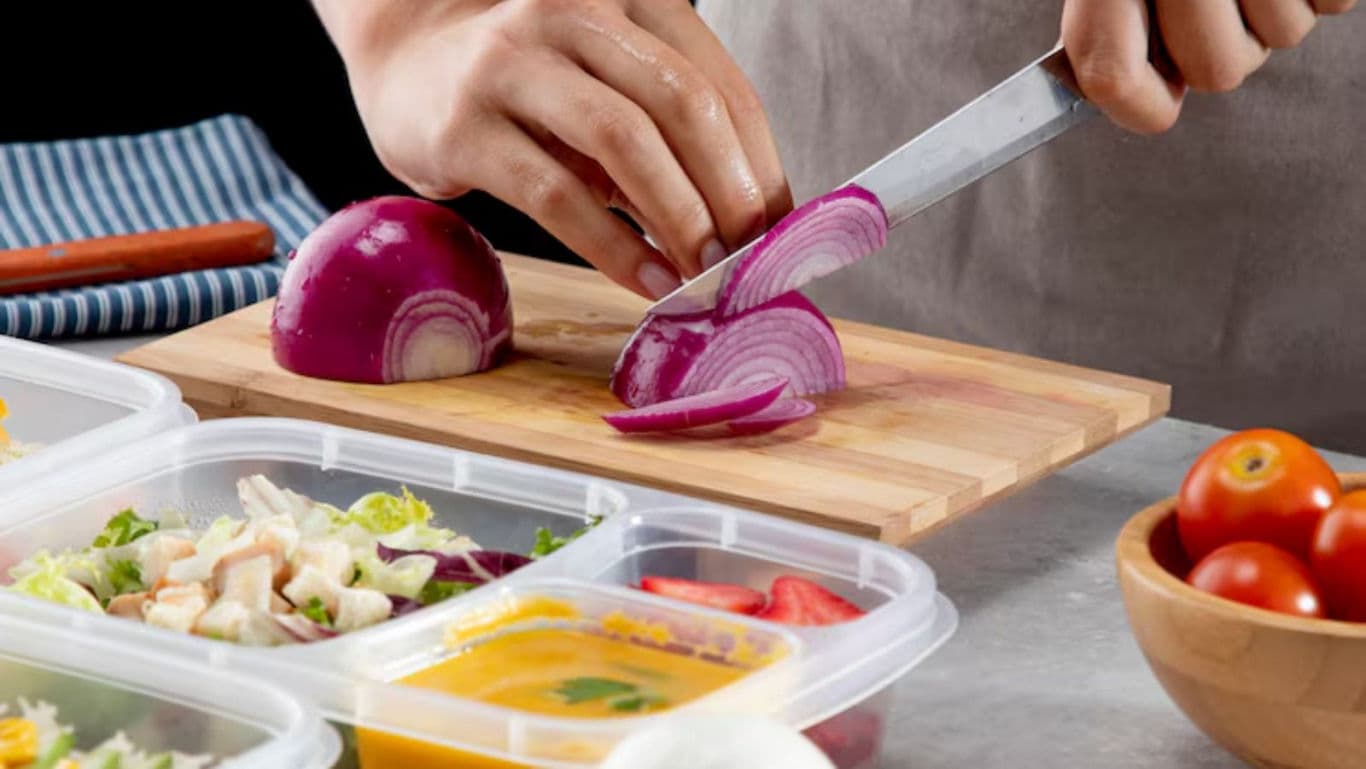 Person Slicing Red Onion for Meal Preparation