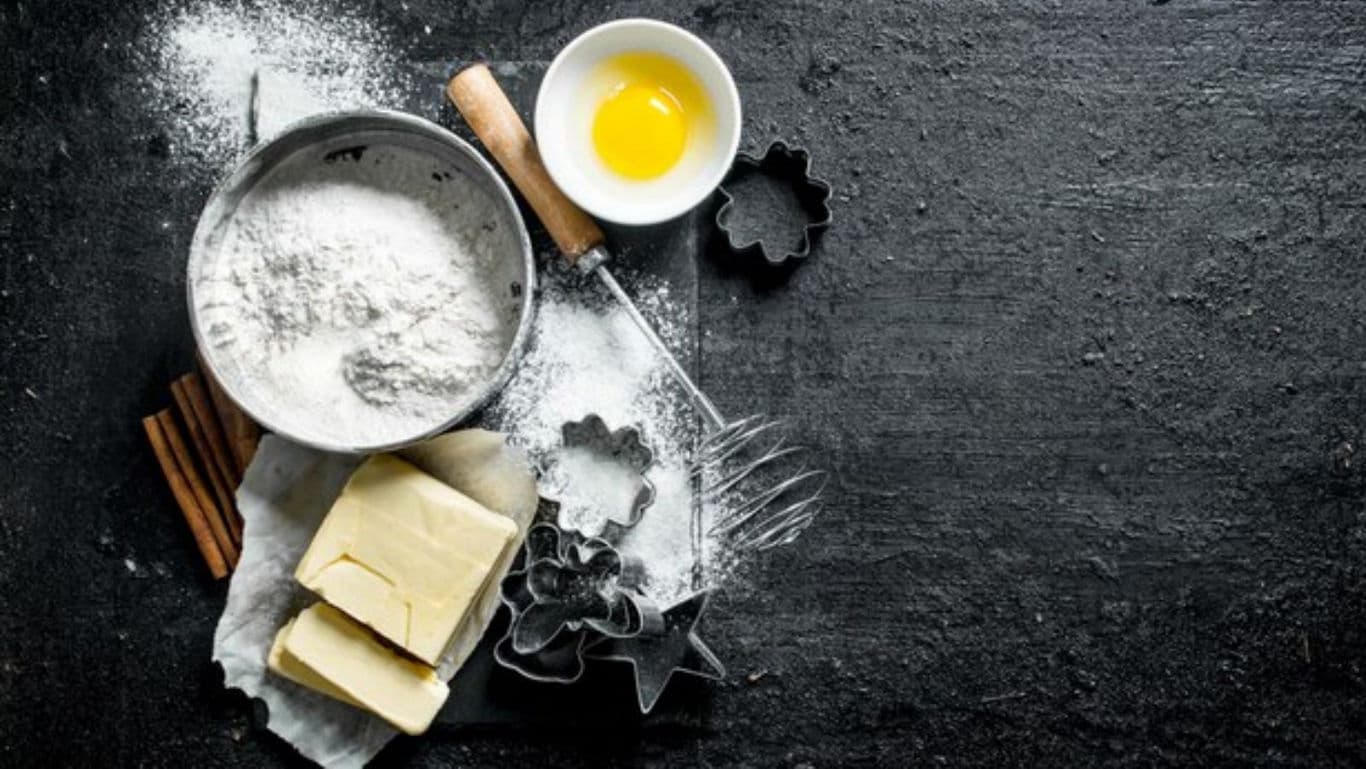 Baking ingredients and utensils on dark countertop