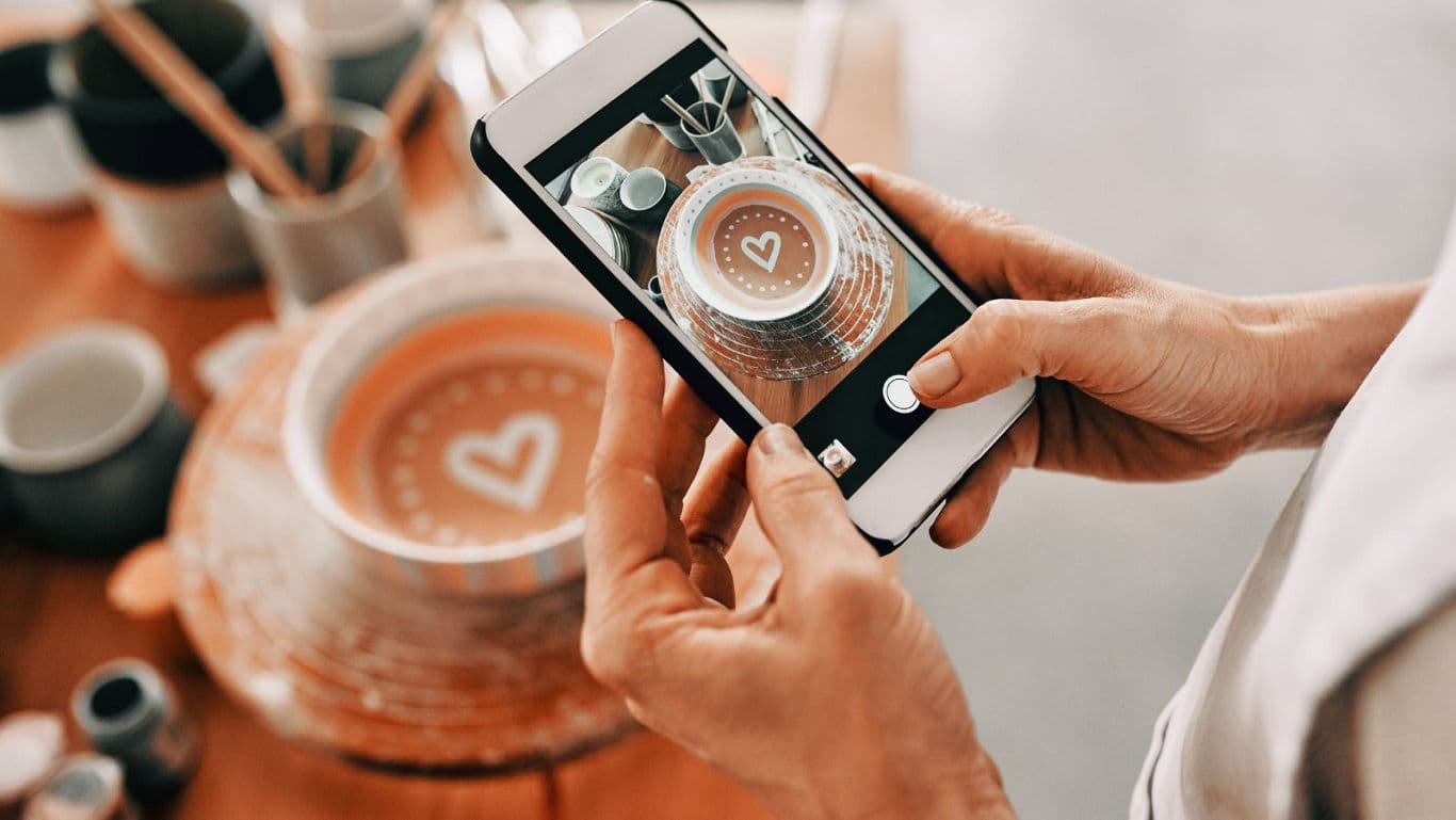 Person photographing heart design on dessert