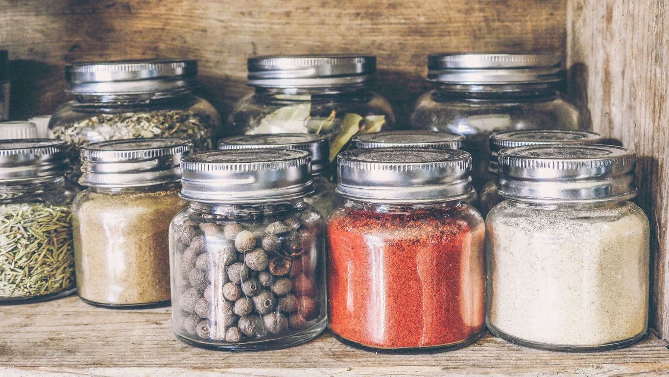 Assorted spices in glass jars on shelf