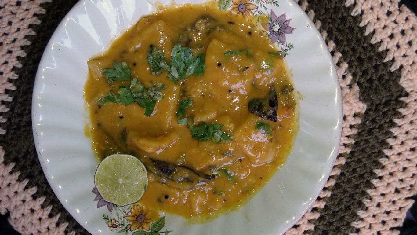 Bowl of yellow curry with herbs
