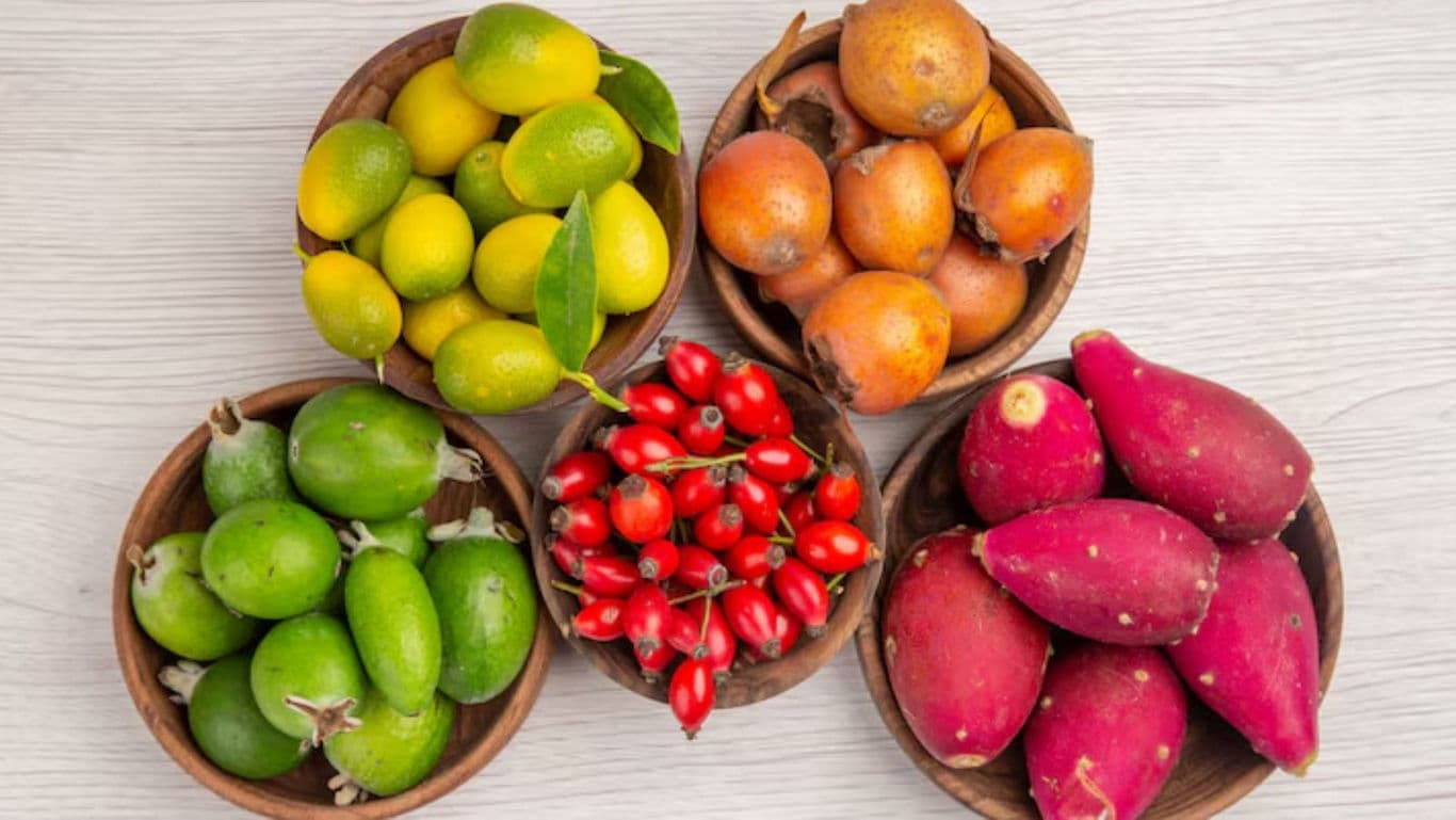 Assorted exotic fruits in wooden bowls on table