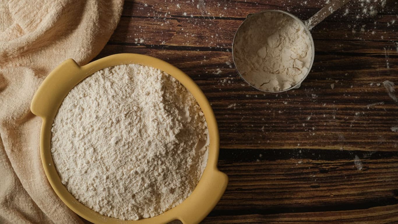 Bowl of flour on rustic wooden table