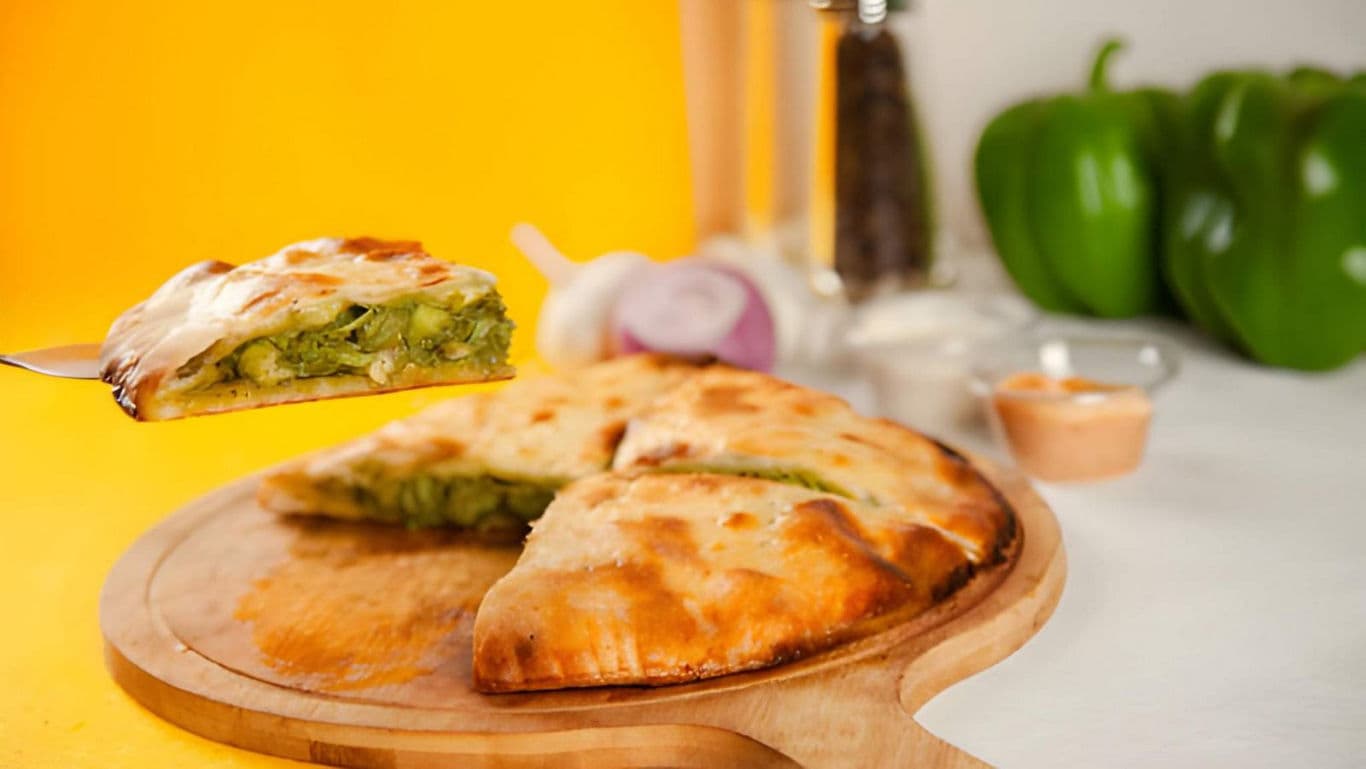 Vegetable stuffed pie slice on wooden board