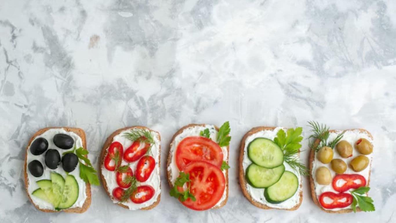 Assorted vegetable open sandwiches on marble background