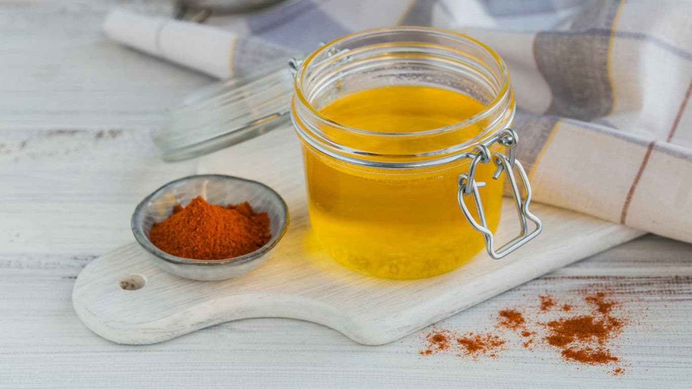 Glass jar of clarified butter with ground spice