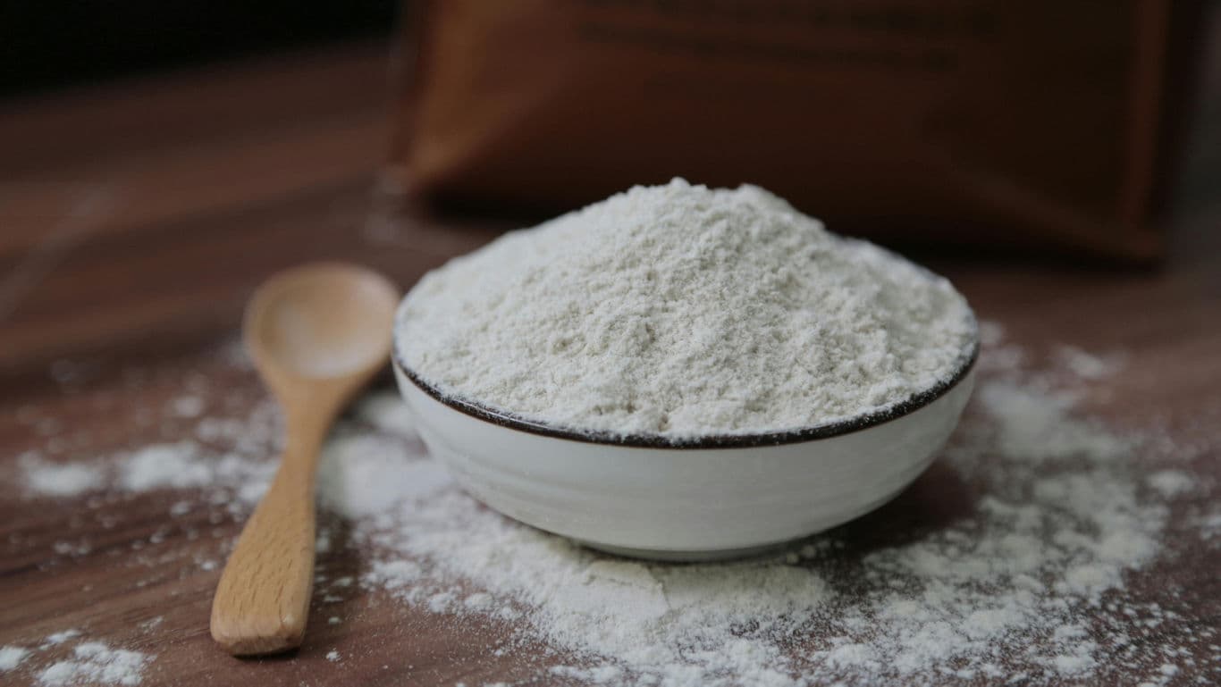 Bowl of white flour on wooden table