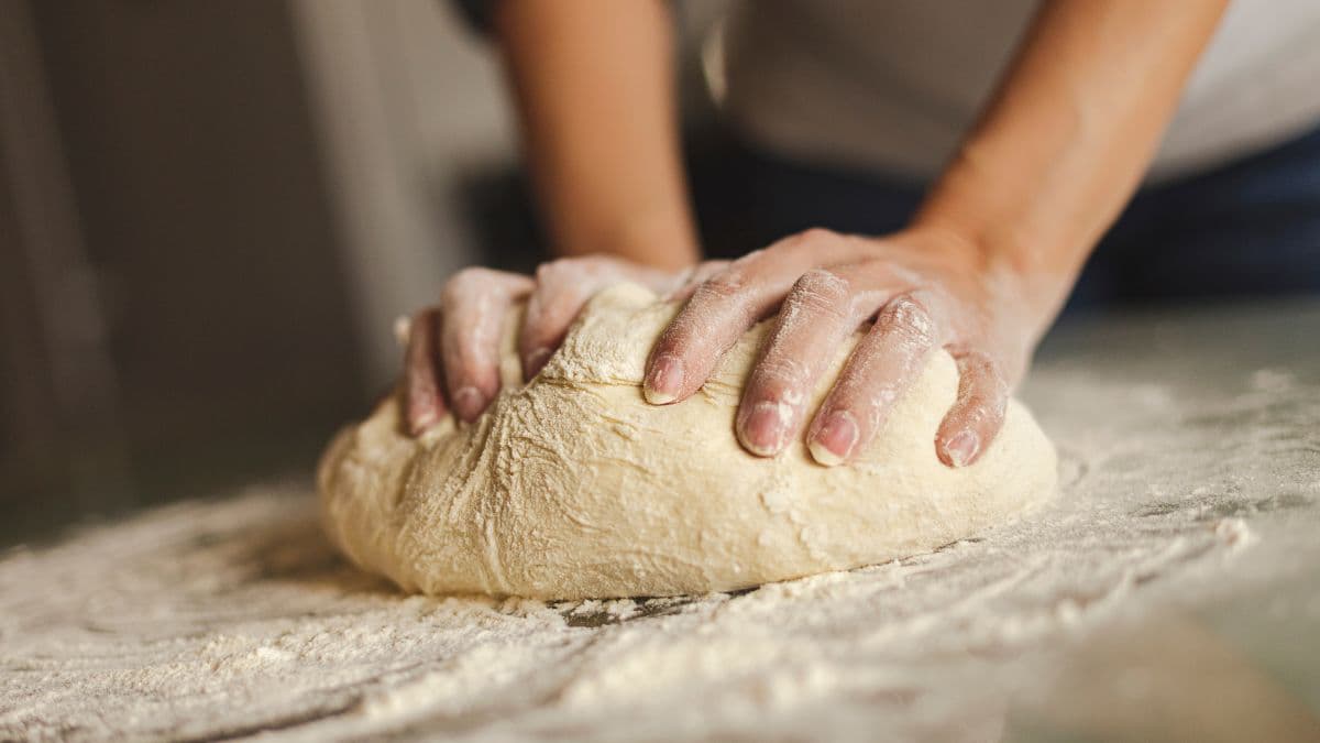woman kneading dough in a bowl