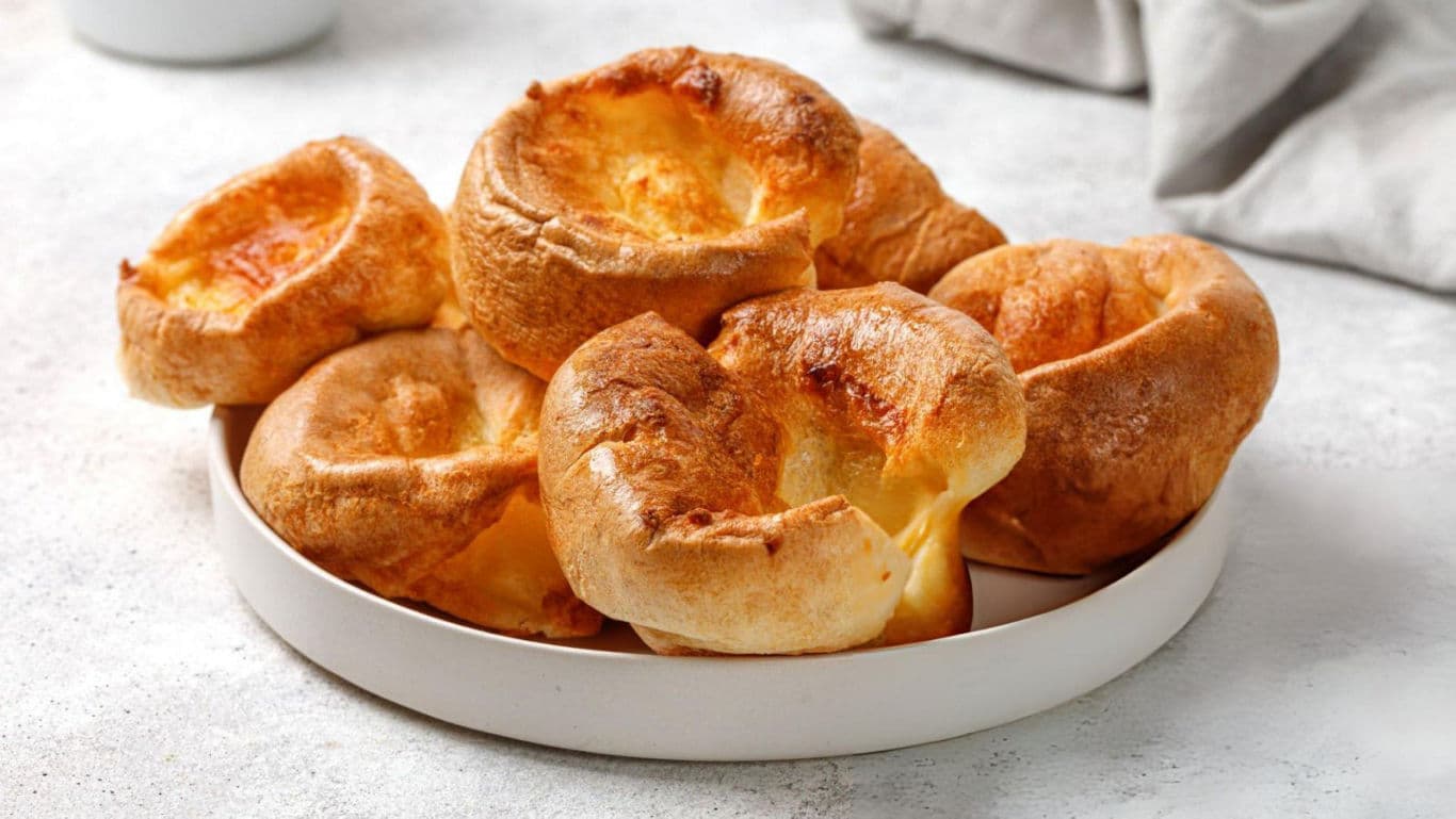 Golden Yorkshire Puddings on White Plate