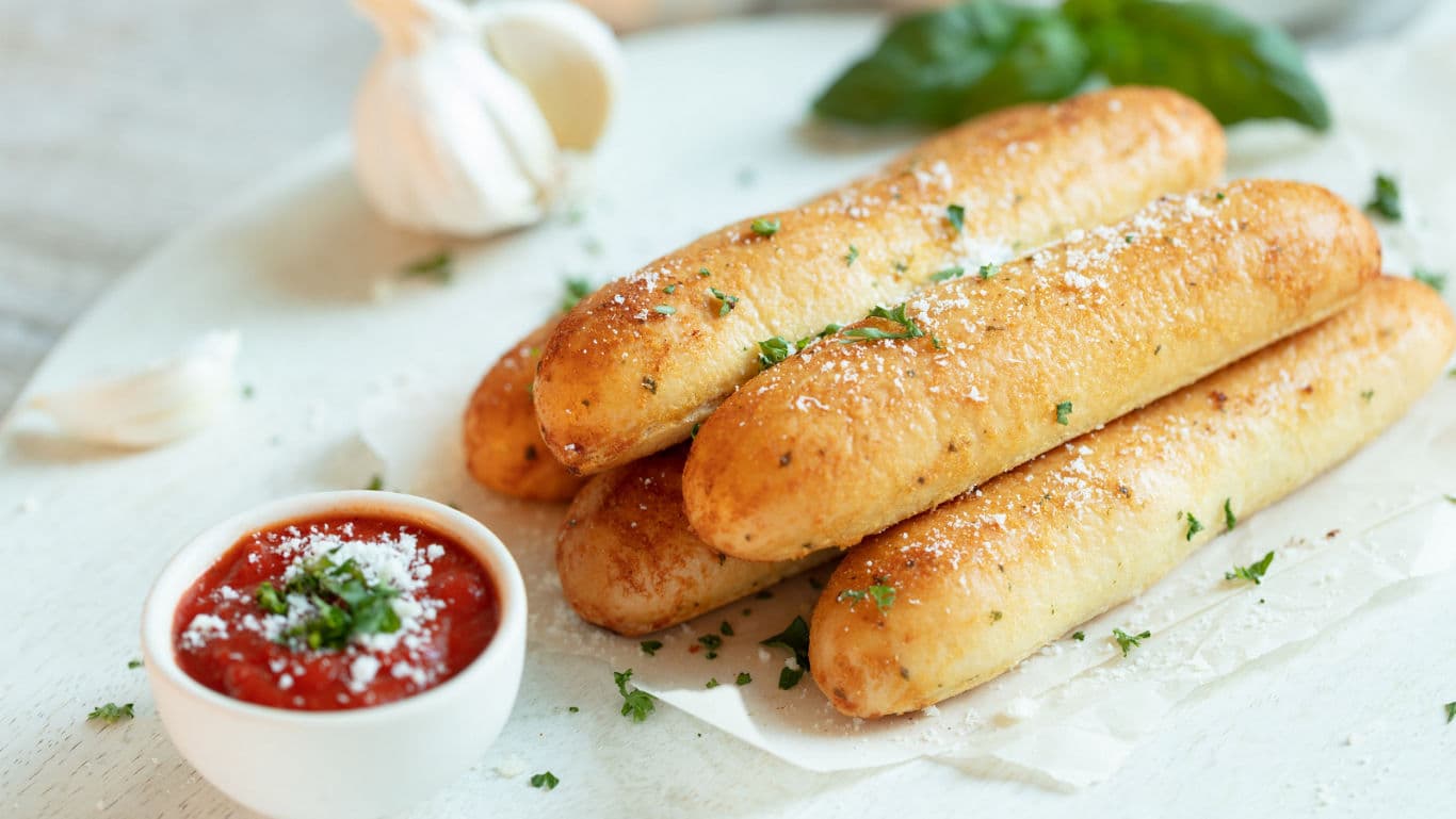 Freshly baked Khapli wheat garlic breadsticks brushed with garlic butter