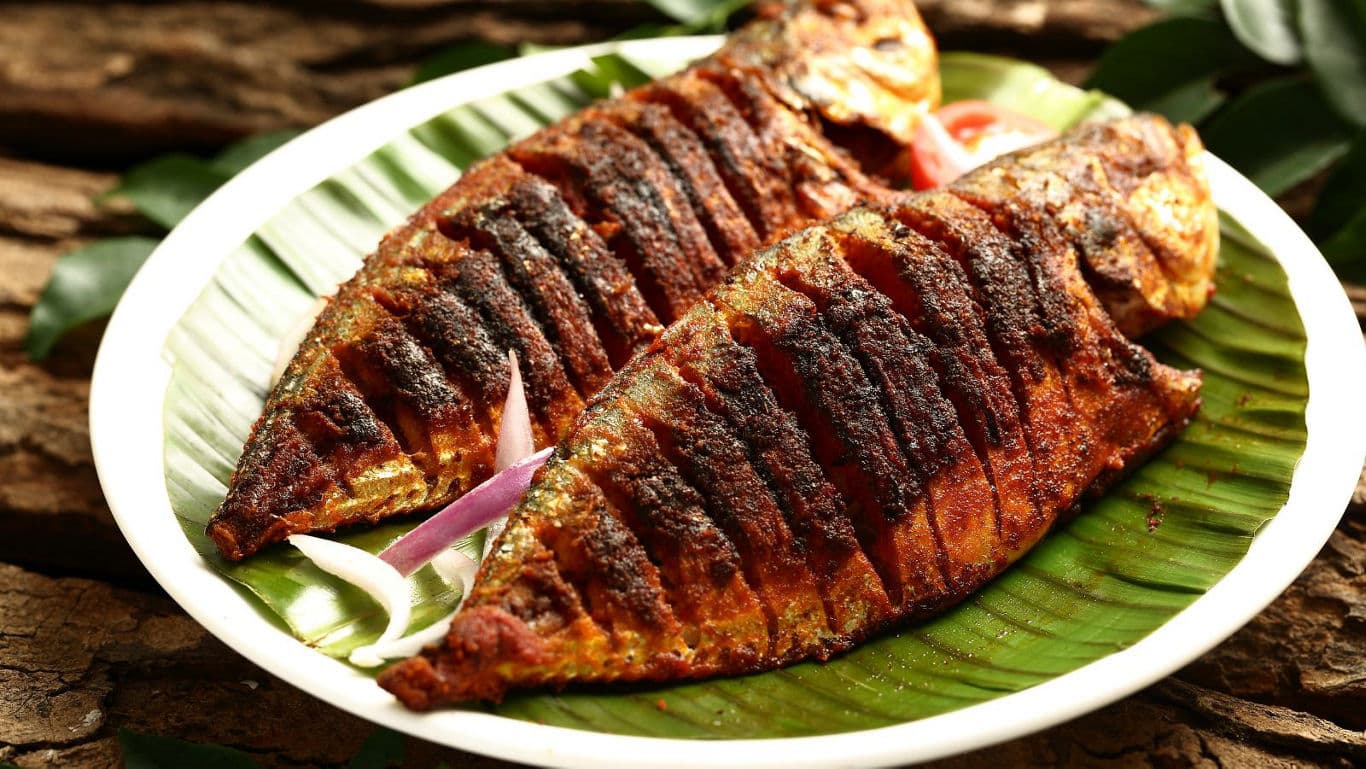 Spicy grilled whole fish on banana leaf