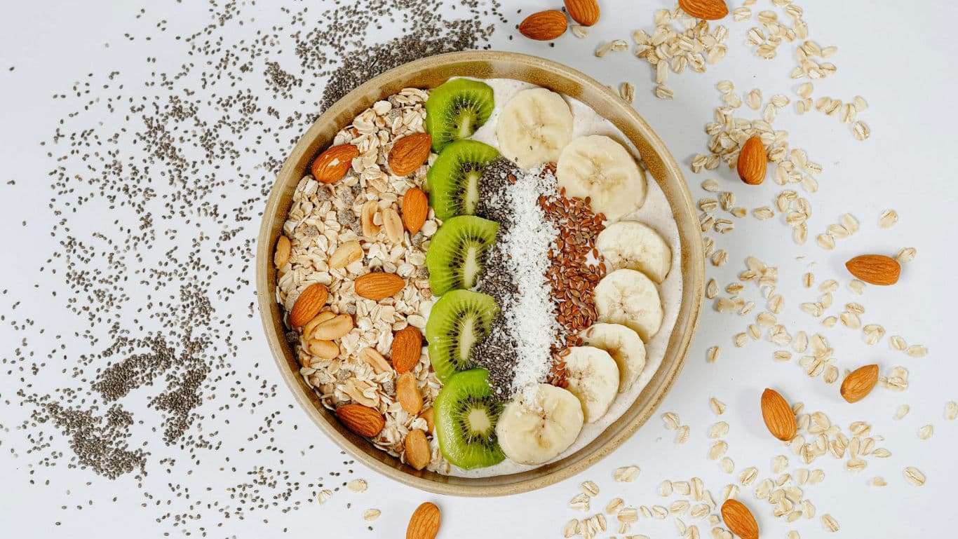 A millet breakfast bowl topped with fresh fruit and nuts