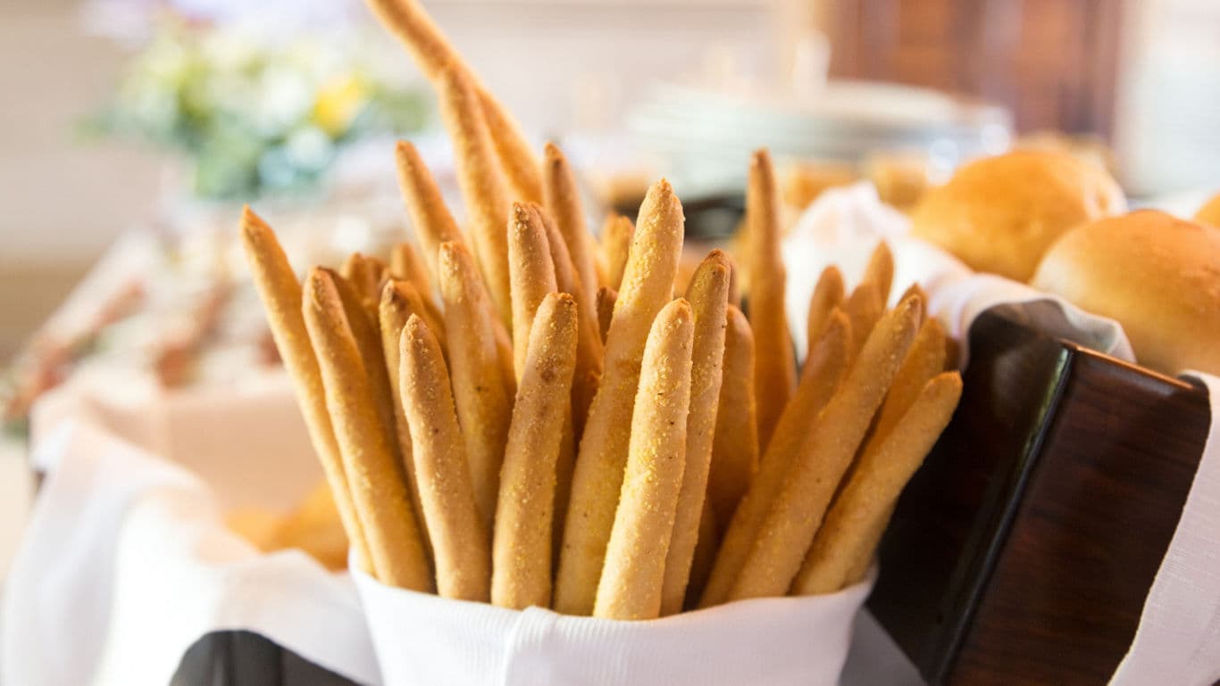 Basket of breadsticks on buffet table