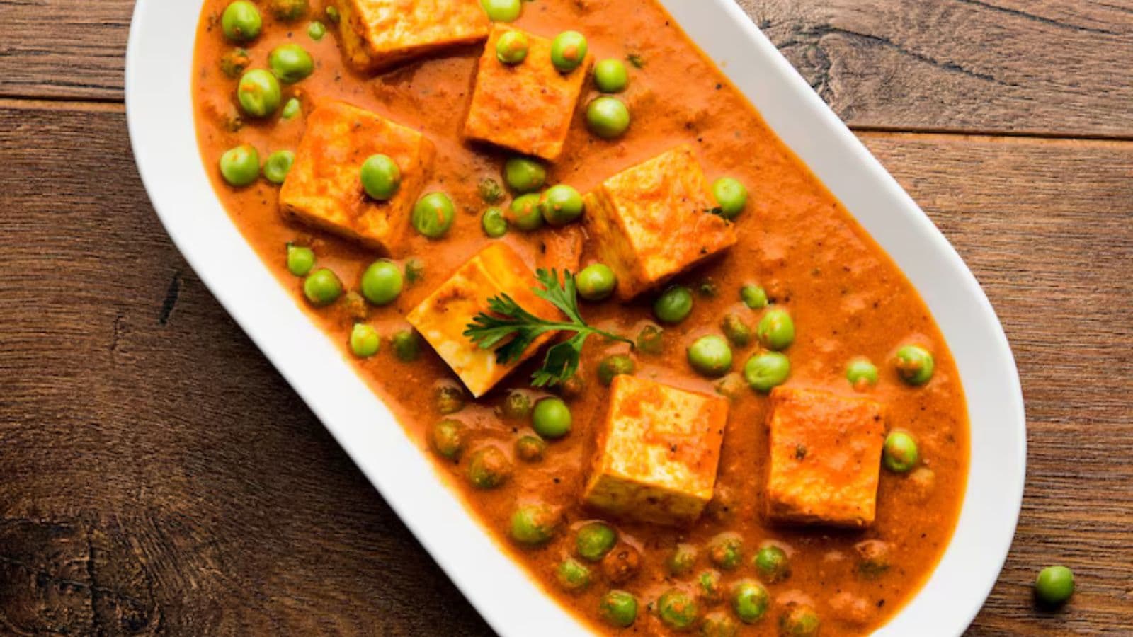 Paneer curry with peas in white dish