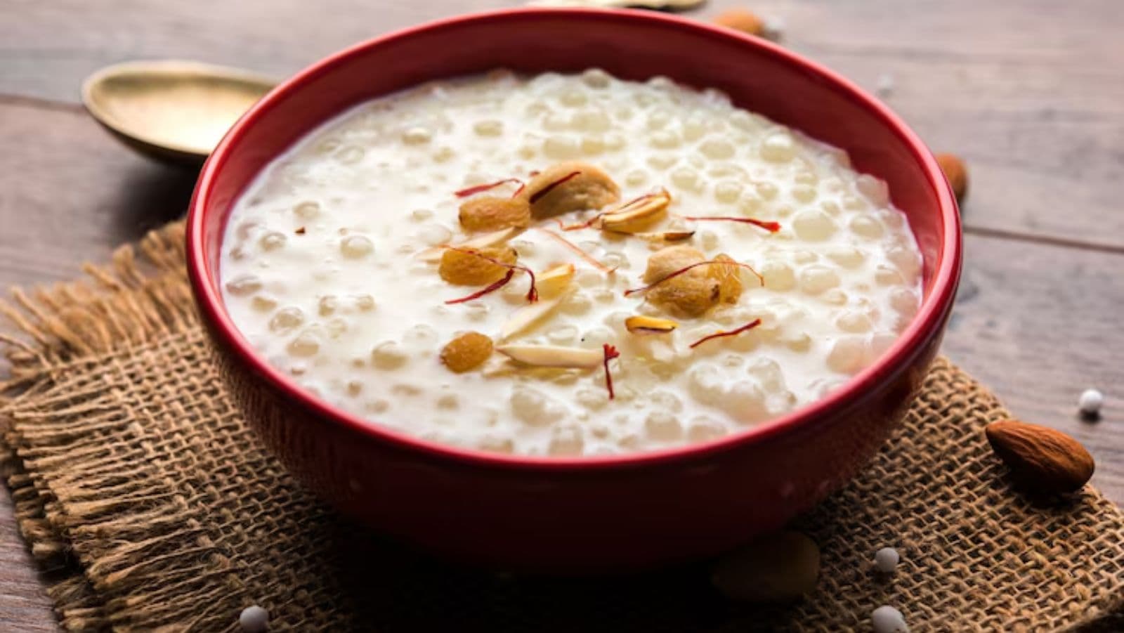 Creamy dessert with almonds in red bowl